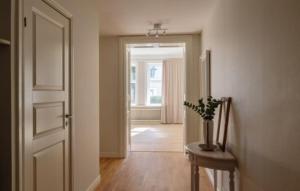 un pasillo con una puerta y un jarrón con una planta en Lägenhet i sekelskifteshus centrala Kalmar, en Kalmar