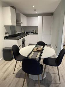 a kitchen with a table and chairs in a room at Luxury Spring Stays Lichfield City Centre 2 Bedroom Apartment With Free Secure Parking in Lichfield