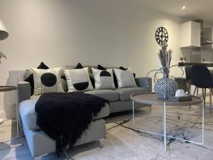 a living room with a couch and a table at Luxury Spring Stays Lichfield City Centre 2 Bedroom Apartment With Free Secure Parking in Lichfield