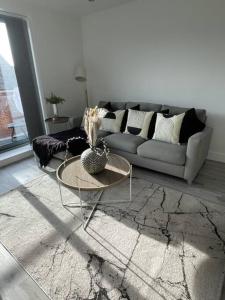 uma sala de estar com um sofá e uma mesa em Luxury Spring Stays Lichfield City Centre 2 Bedroom Apartment With Free Secure Parking em Lichfield