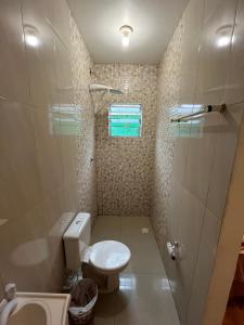 a small bathroom with a toilet and a shower at Suíte Hostel Curitiba in Curitiba