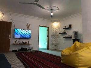 a living room with a door and a television on a wall at Euphoria bed & breakfast in Wadi Musa