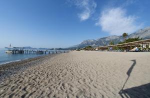 a person walking on a beach near the ocean at Seven Seas Hotel Life - Ultra All Inclusive & Kids Concept in Kemer