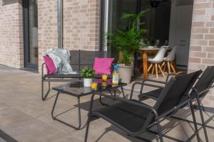 eine Terrasse mit Stühlen und einem Tisch mit Getränken darauf in der Unterkunft HAMA Design Homes Paderborn 4 Apartments in Paderborn