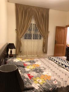 een slaapkamer met een groot bed en een bloemendeken bij Luxurious Family Holiday Home in Temara