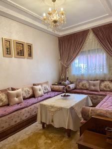 a living room with a purple couch and a table at Luxurious Family Holiday Home in Temara