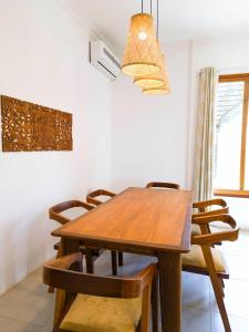 - une salle à manger avec une table et des chaises en bois dans l'établissement The Cliff 2 Bedroom Beach Apartment, à Mazizini