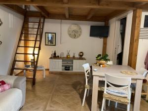 sala de estar con escalera, mesa y sillas en La casetta di Vany, en Nova Siri