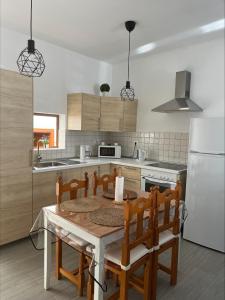 eine Küche mit einem Tisch und Stühlen sowie einem weißen Kühlschrank in der Unterkunft CASA LOS ABUELOS in Puerto del Rosario