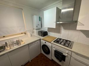 małą kuchnię z kuchenką i pralką w obiekcie A stunning apartment in Paddington w Londynie