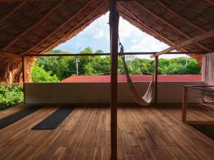 um quarto amplo com uma rede de descanso num piso de madeira em Casa Matilda - Palomino em Palomino