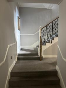 klatka schodowa w domu z białymi ścianami i dywanem w obiekcie A stunning apartment in Paddington w Londynie