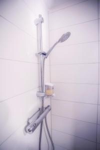 y baño con ducha con cabezal de ducha. en Charmantes Studio Apartment in Bestlage im Stadtzentrum mit Balkon & self checkin - City Loft 3 - en Colonia