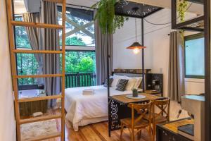 a bedroom with a bed and a table and a desk at Lofts Kayser Haus in Urubici