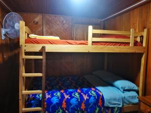 a bedroom with two bunk beds and a fan at LA TRANQUILIDAD in Mindo