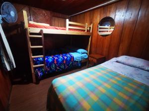 a bedroom with two bunk beds and a ladder at LA TRANQUILIDAD in Mindo