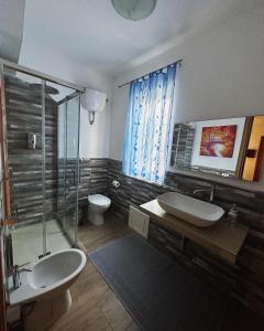 ein Bad mit einem Waschbecken, einer Dusche und einem WC in der Unterkunft Beppo's B&B in Carbonia