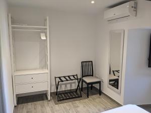 een slaapkamer met een stoel en een spiegel bij Apartamento Rural Zahora in Hervás