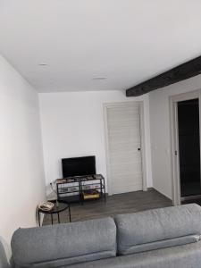 - un salon avec un canapé et une télévision dans l'établissement Apartamento Rural Zahora, à Hervás
