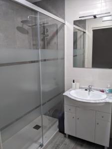La salle de bains est pourvue d'une douche en verre et d'un lavabo. dans l'établissement Apartamento Rural Zahora, à Hervás