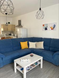 sala de estar con sofá azul y mesa de centro blanca en CASA LOS ABUELOS en Puerto del Rosario