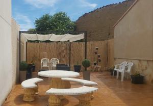 un patio con mesa, sillas y una valla en El Colibrí de Taraza, 