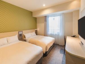 ein Hotelzimmer mit 2 Betten und einem Fenster in der Unterkunft Sotetsu Fresa Inn Osaka Namba in Osaka