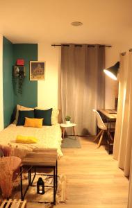 1 dormitorio con cama, mesa y piano en Beau studio proche gare, en Gagny