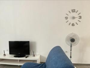 sala de estar con sofá y reloj en la pared en CASA LOS ABUELOS, en Puerto del Rosario