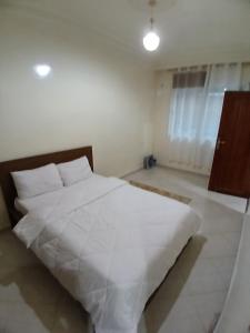 um quarto com uma grande cama branca num quarto em Chambre Royale Avec toilette Interne em Casablanca