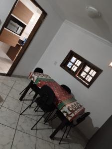 Una mesa y sillas en una habitación con ventana. en Guarujá, Linda casa em condomínio fechado ., en Guarujá