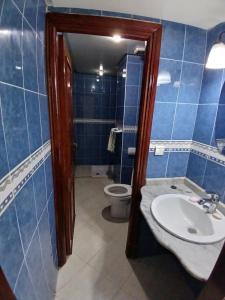 uma casa de banho em azulejos azuis com um lavatório e um WC em Chambre Royale Avec toilette Interne em Casablanca