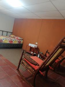 pokój z krzesłem i łóżkiem w obiekcie "La Casa del Abuelo" w mieście Santa Ana