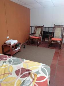 Pokój z 2 fotelami bujanymi i łóżkiem w obiekcie "La Casa del Abuelo" w mieście Santa Ana