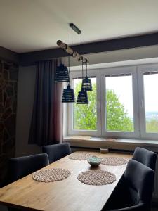a dining room with a table and two windows at MARMOT Mountain Apartment so saunou a hydromasážnou vaňou in Nový Smokovec