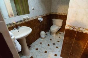 y baño con aseo y lavamanos. en Hotel Sierra Dorada en Ayacucho