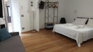 1 dormitorio con cama blanca y sofá en Casa Dei Normanni: DEA al mare, en Cefalú