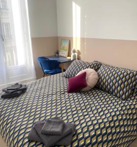 ein Schlafzimmer mit einem Bett mit einem Kissen und einem Stuhl in der Unterkunft Le Central - Coeur historique - Netflix/Disney+ in Soissons