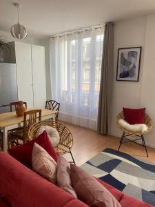 a living room with a red couch and a table at Le Central - Coeur historique - Netflix/Disney+ in Soissons +20 photos