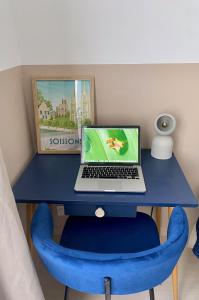 蘇瓦松的住宿－Le Central - Coeur historique - Netflix/Disney+，一张蓝色的桌子,上面有一台笔记本电脑