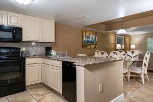 una cocina con armarios blancos y una mesa con sillas. en Legacy Vacation Resorts Kissimmee & Orlando - Near Disney, en Kissimmee