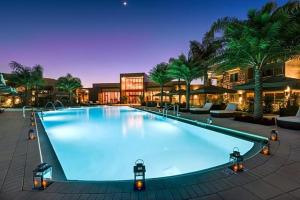 - une grande piscine d'eau bleue la nuit dans l'établissement GORGEOUS - Luxurious 4 bedroom House 10 min drive to Disney World, à Orlando