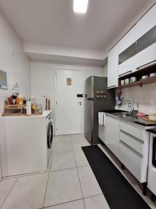 eine Küche mit einer Waschmaschine, einem Trockner und einem Kühlschrank in der Unterkunft Ponte Laguna, Pq Burle Marx, Apto 1 dorm e Varanda in São Paulo