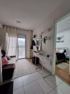 ein weißes Wohnzimmer mit einem Sofa und einem Schreibtisch in der Unterkunft Ponte Laguna, Pq Burle Marx, Apto 1 dorm e Varanda in São Paulo