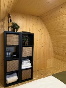 a black book shelf in a room with wooden walls at Bungalow Madeira - Casa das Lages - Almancil - Quinta do Lago in Almancil