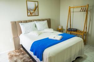a bedroom with a large bed with a blue blanket at Loft vista da serra in Serra de São Bento