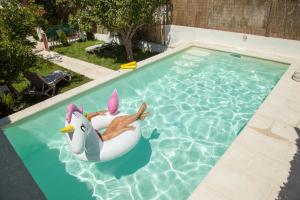 a woman laying in an inflatable whale in a swimming pool at Casa do Sossego in Igrejinha