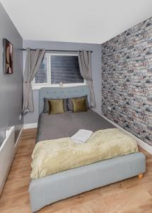 um quarto com uma cama grande e uma parede de tijolos em SEASIDE SPACIOUS apartment em Peterlee