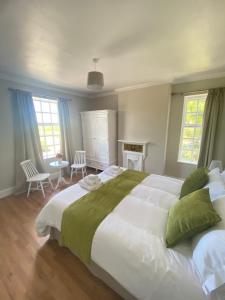 a bedroom with a large white bed with green pillows at The Old Postie Bed & Breakfast in Annesley