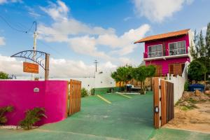 a pink building with a basketball court in front of it at Pousada Loft vista da serra in Serra de São Bento